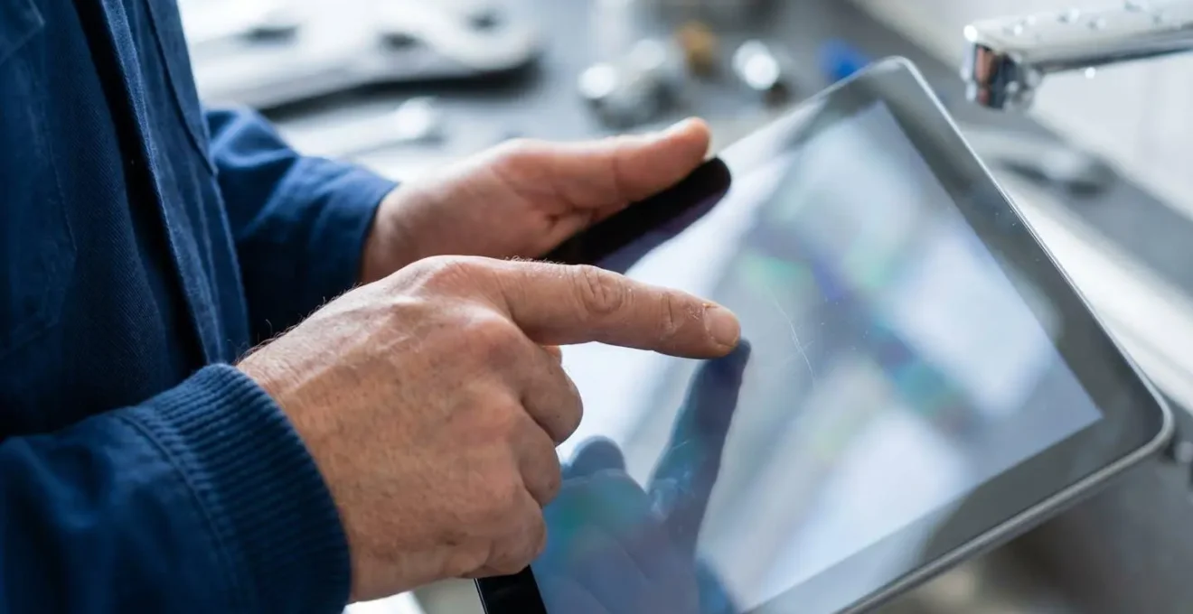 Gros plan sur des mains signant un document numérique sur tablette lors d'une intervention d'urgence